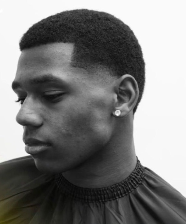 Perfil de un chico con un fade limpio y línea marcada
